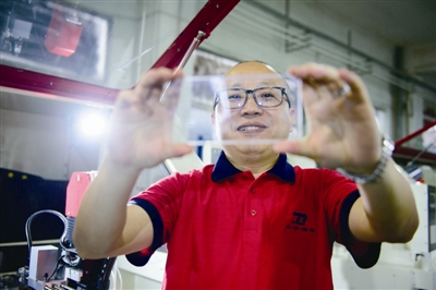大宇精雕的董事長(zhǎng)雷萬春展示精雕工藝生產(chǎn)的手機(jī)玻璃蓋板 大宇精雕的董事長(zhǎng)雷萬春展示精雕工藝生產(chǎn)的手機(jī)玻璃蓋板